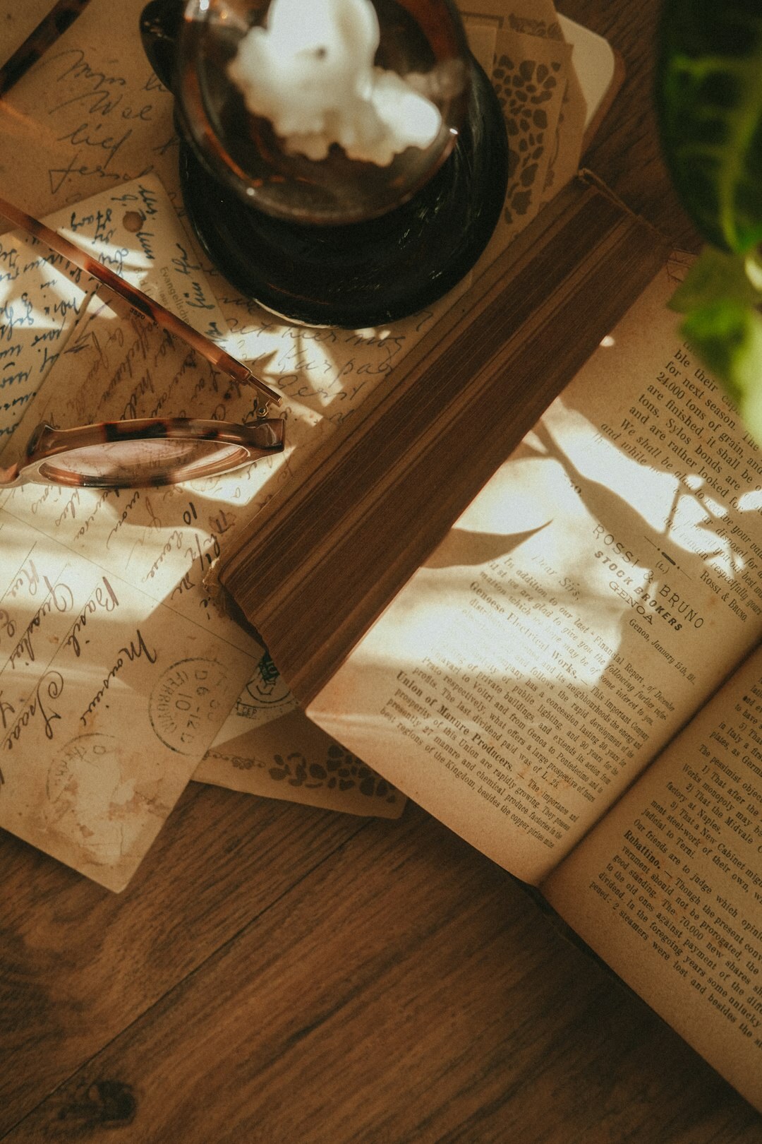Editorial desk with notebooks, printed research papers and a warm desk lamp